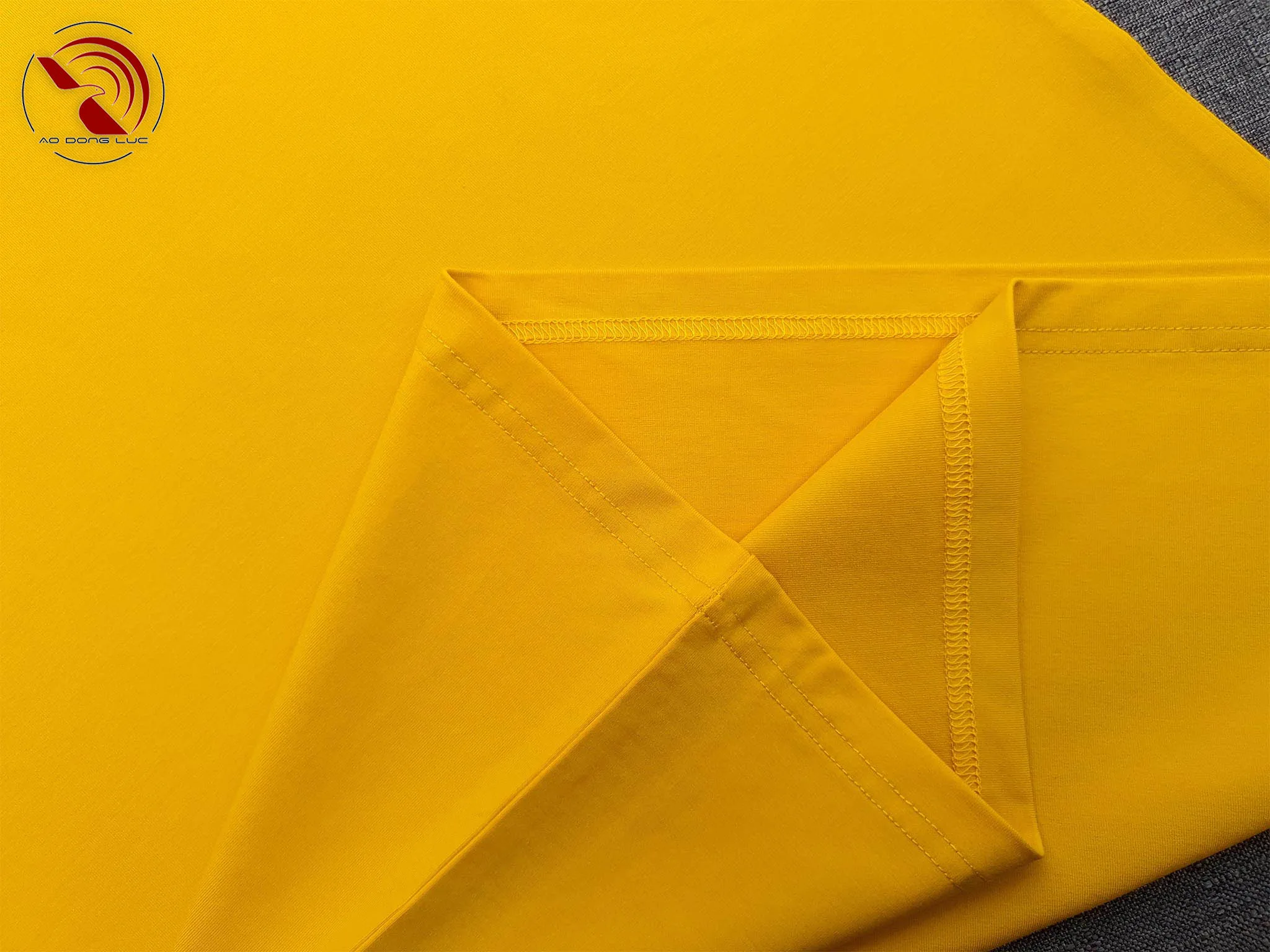 Chi tiết vạt áo áo thun cổ tròn ngắn tay cotton cao cấp màu vàng đậm