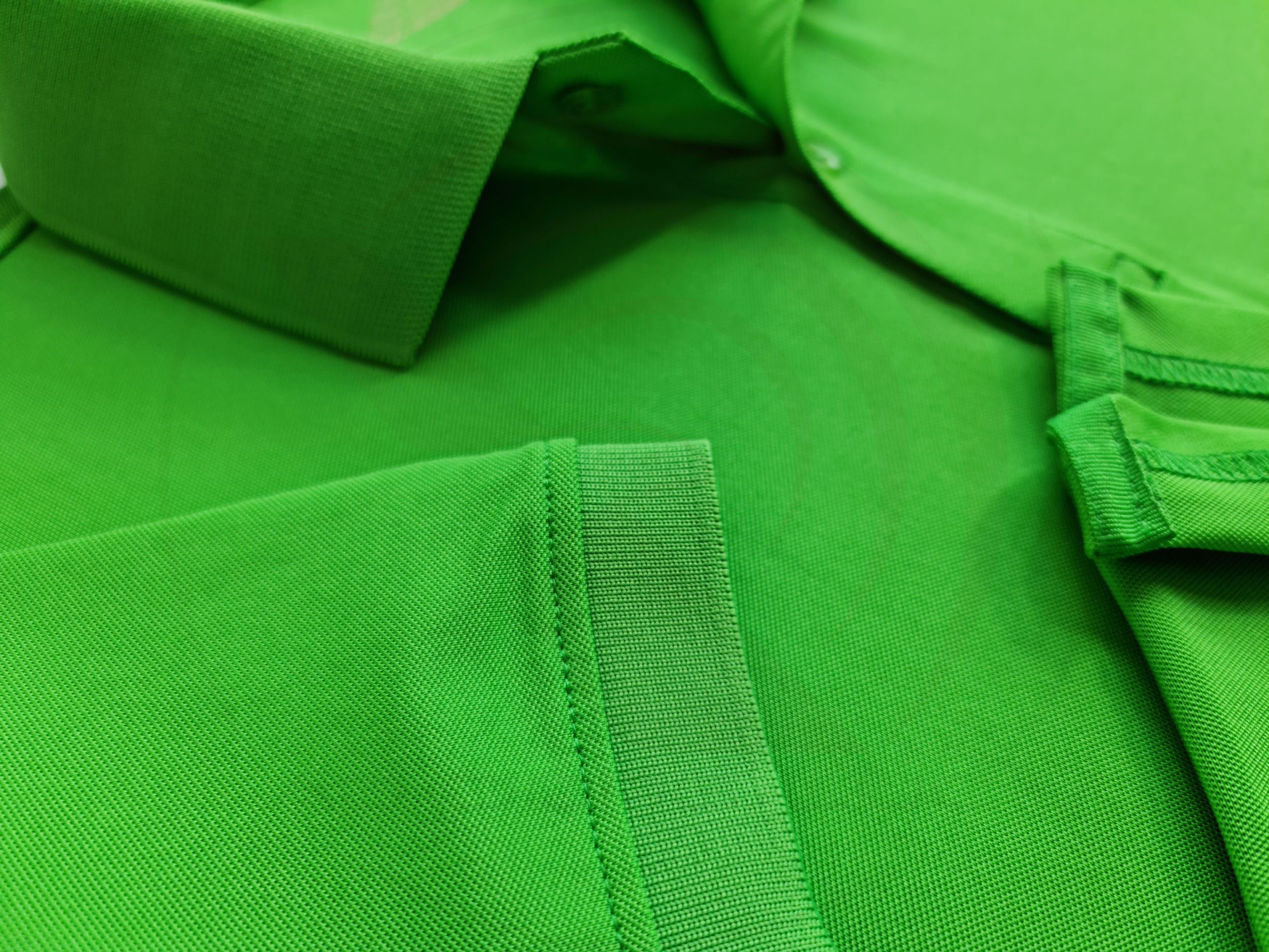 Chi tiết đường may và tà áo áo thun cổ trụ polo bo trơn xanh lá