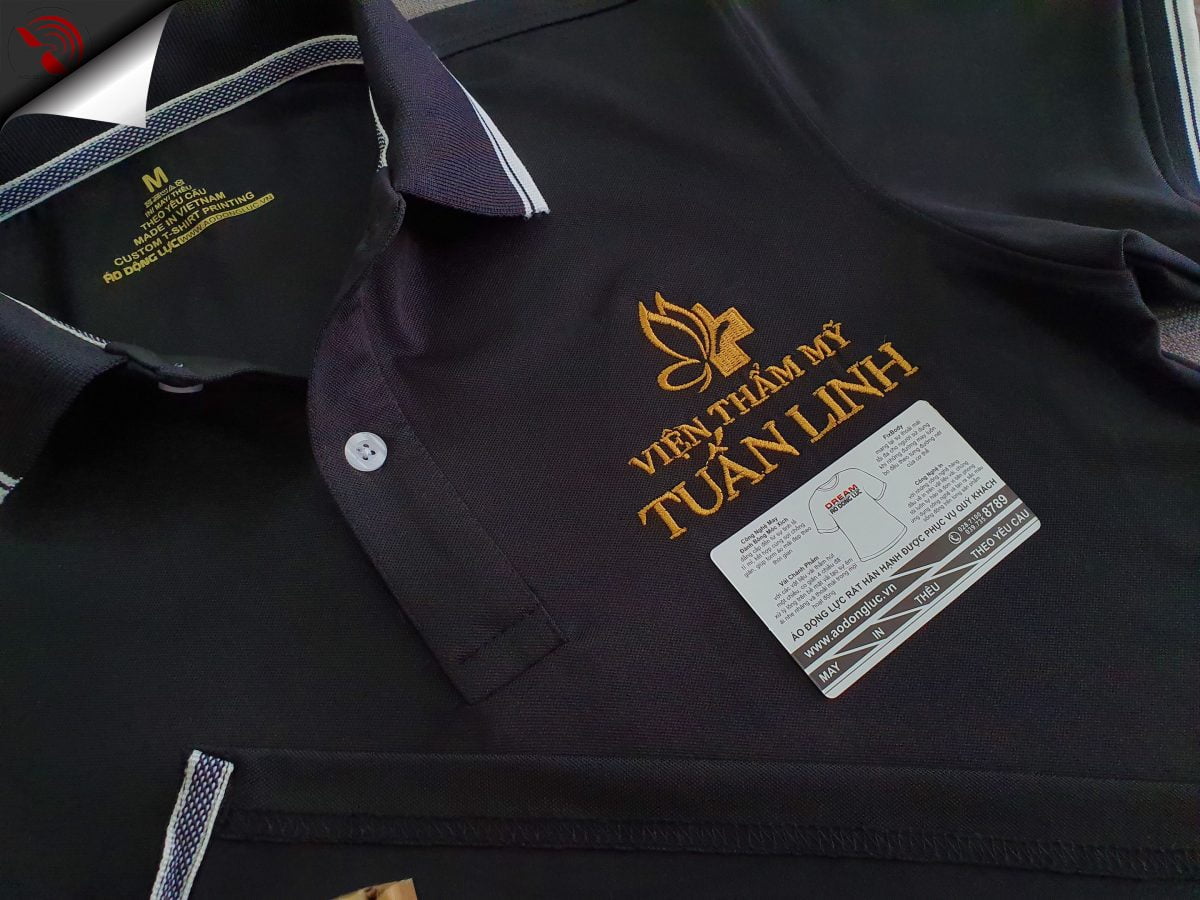 Hình thêu logo lên áo thun đồng phục polo màu đen dệt bo theo yêu cầu