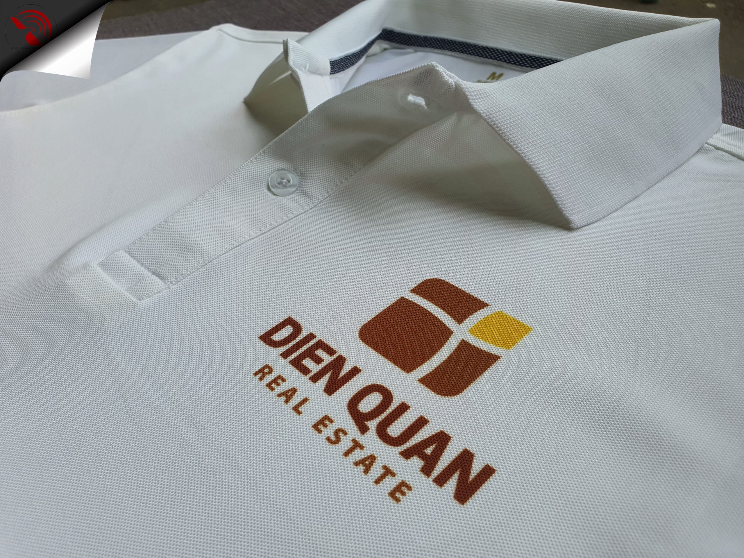 Hình in chuyển nhiệt logo lên áo thun đồng phục polo bo trơn màu trắng