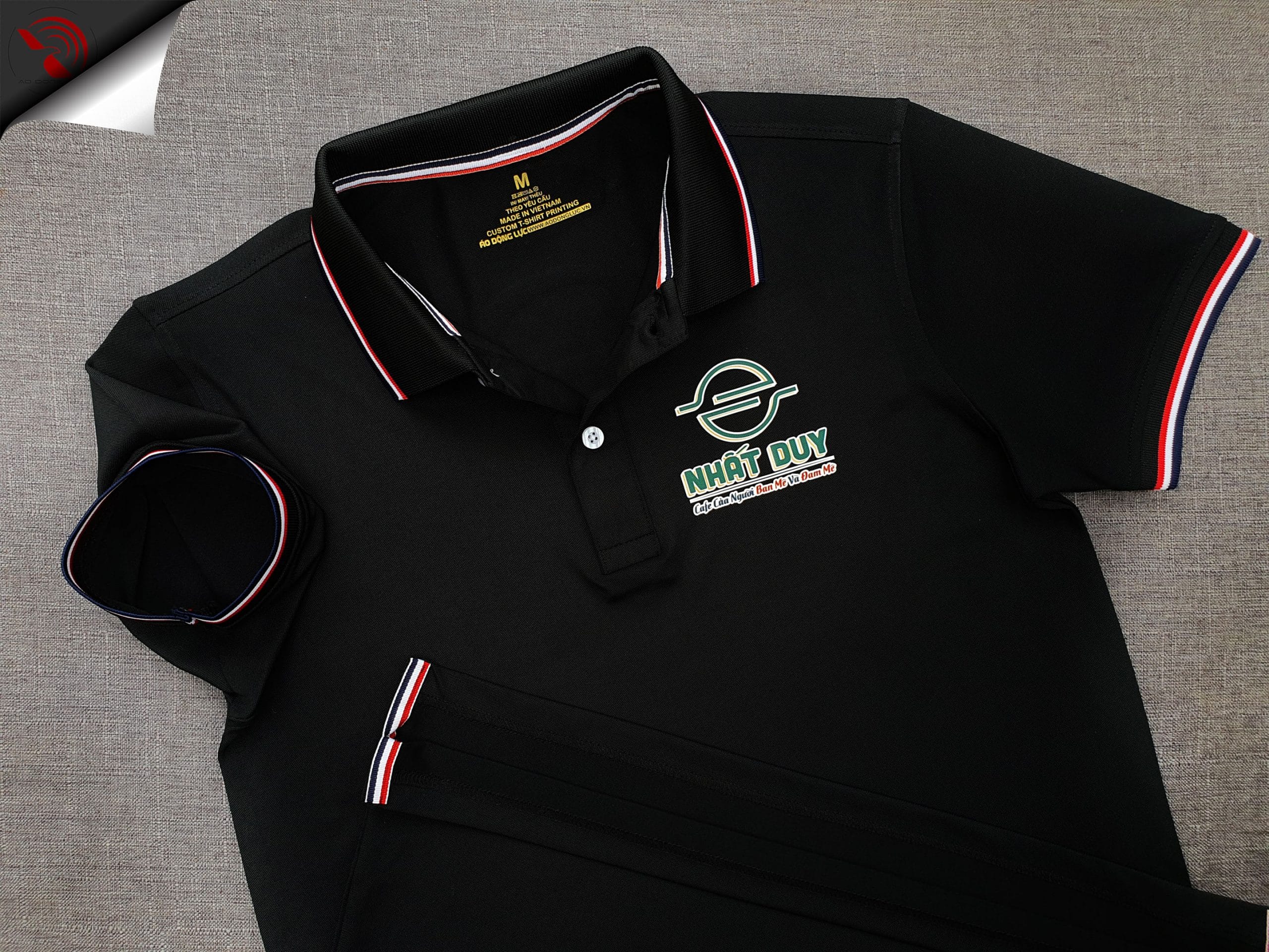 Đồng phục áo thun polo bo sọc màu đen in decal logo