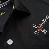 Hình thêu vi tính logo lên áo thun đồng phục polo bo trơn màu đen