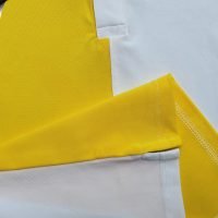 Chi tiết áo thun đồng phục polo may phối thân vải trắng vàng