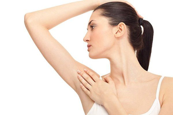 Người phụ nữ đang giơ tay kiểm tra hạch dưới cánh tay.